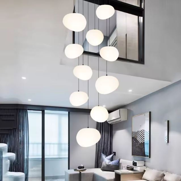 Suspension escalier boule blanche au style moderne, idéale pour illuminer avec élégance un duplex ou un séjour en hauteur.