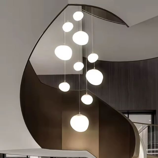 Suspension escalier boule au design flottant, sublimée par un escalier hélicoïdal et une mise en scène architecturale contemporaine.