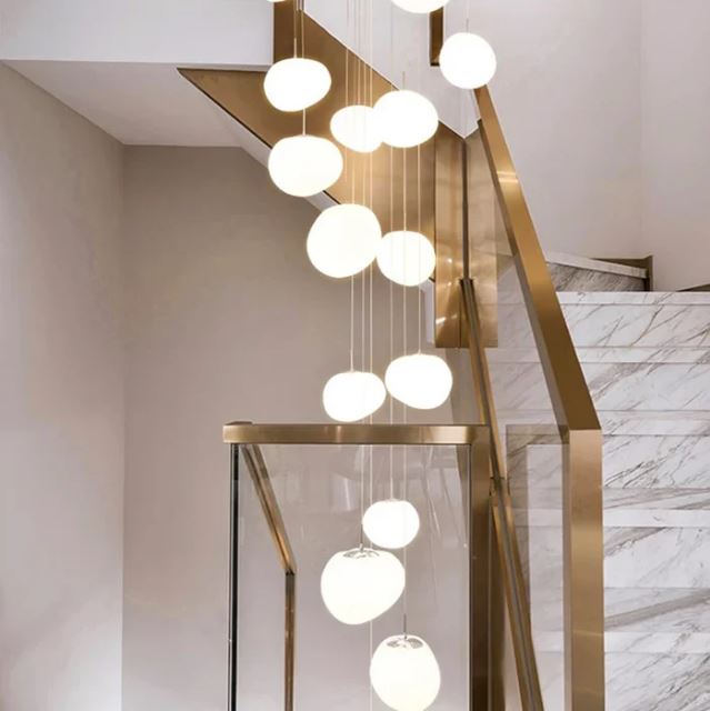Suspension escalier boule, parfaite pour un escalier moderne aux finitions marbre et laiton.