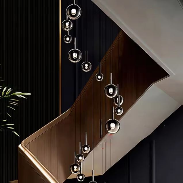 Suspension d’escalier en cascade, globes en verre fumé noir, style hôtel particulier chic et moderne.