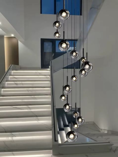 Longue suspension d’escalier en cascade, globes en verre fumé noir, style contemporain premium.