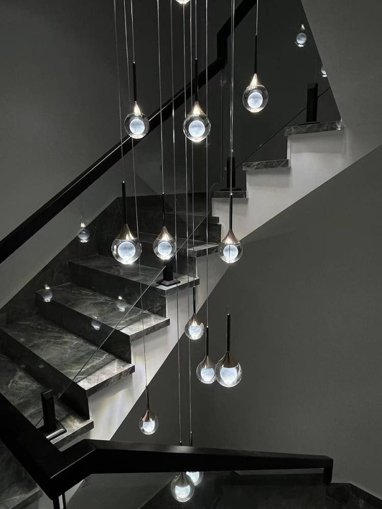 Suspension d’escalier en cascade, sphères en verre transparent à cœur opalin, design contemporain luxe.
