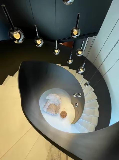 Suspension en cascade pour escalier en colimaçon, globes en verre fumé noir, style architectural chic.