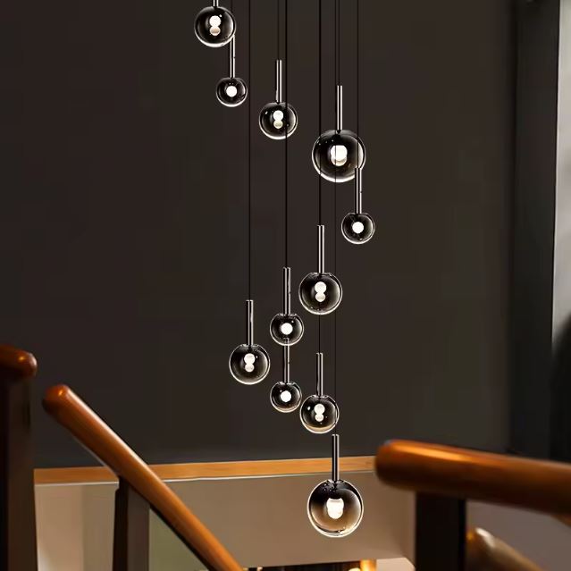 Suspension verticale pour cage d’escalier, globes en verre fumé noir, esprit minimaliste graphique.