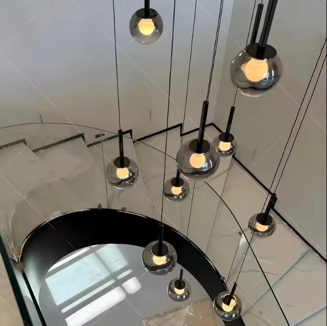 Vue du dessus d’une suspension d’escalier, globes en verre fumé noir, style contemporain raffiné.