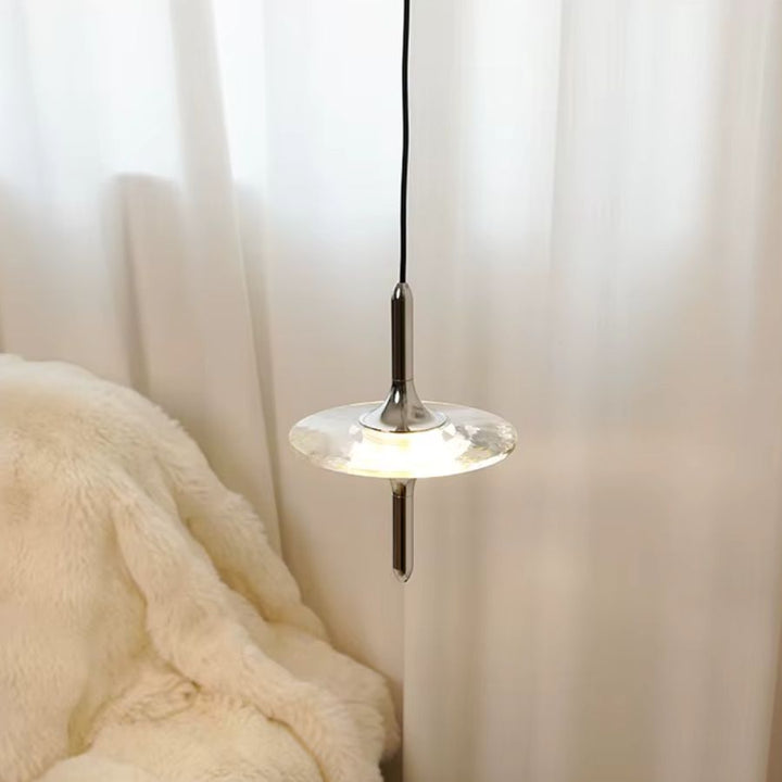 Suspension étoile en cristal K9 et métal chromé près du lit, dans une chambre douce au style contemporain et épuré