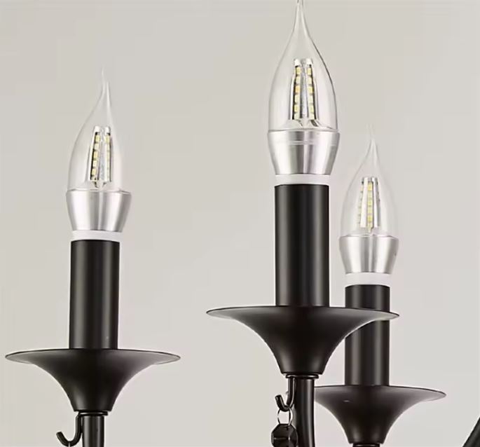 Gros plan sur une suspension en fer forgé avec bougies LED au style médiéval revisité et raffiné.