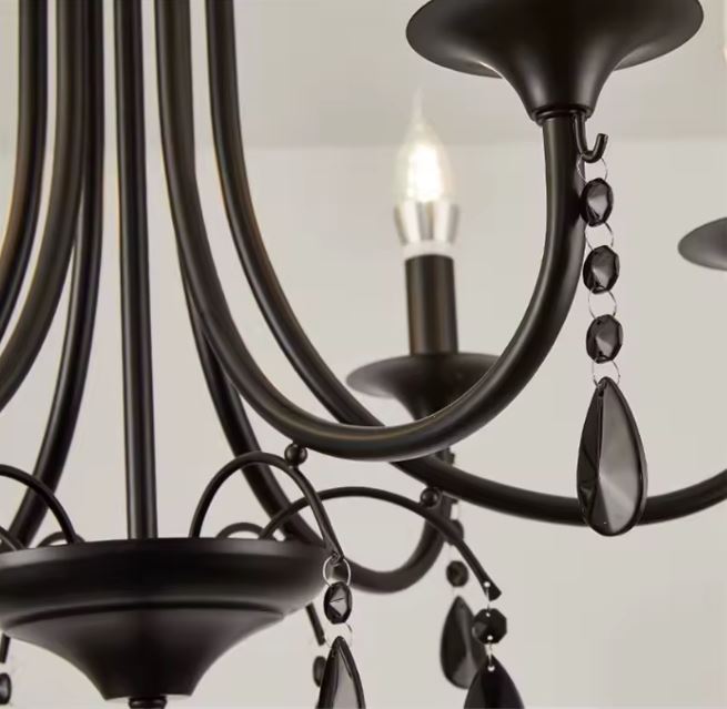 Détail d’une suspension en fer forgé avec pampilles en cristal fumé au style gothique élégant et intemporel.