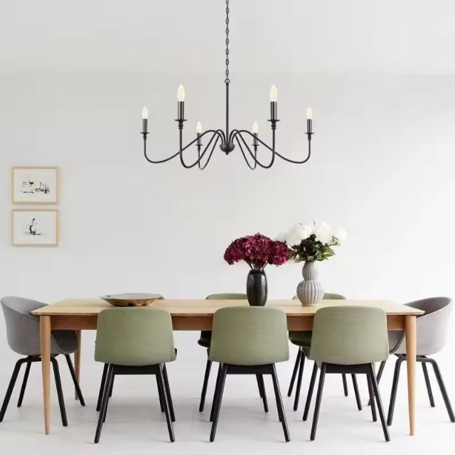 Élégante suspension en fer forgé noire au-dessus d’une grande table à manger au style minimaliste et contemporain.