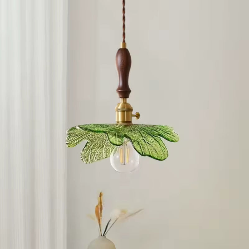 Silhouette végétale en verre vert associée au bois de noyer pour un luminaire suspendu au charme naturel et rétro