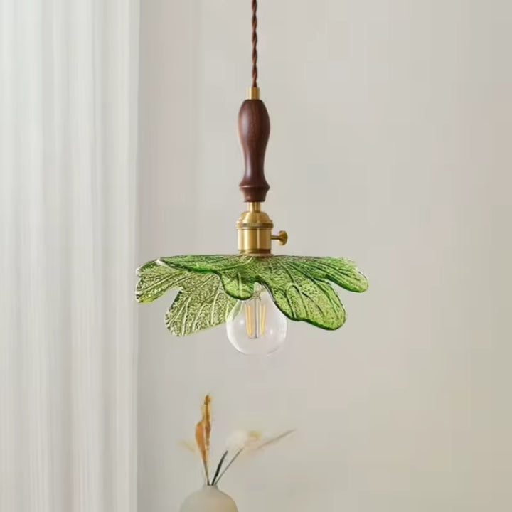 Silhouette végétale en verre vert associée au bois de noyer pour un luminaire suspendu au charme naturel et rétro