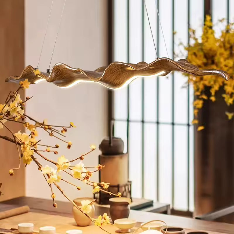 Suspension feuille dorée aux courbes fluides, au style organique et artistique dans un intérieur chaleureux