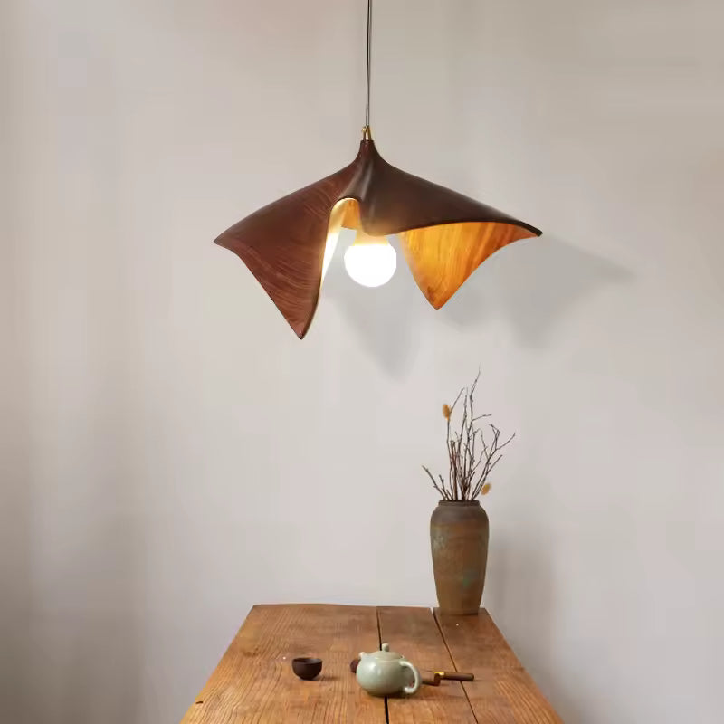 Suspension feuille en résine effet bois brun, aux courbes organiques et sculpturales dans un décor naturel épuré