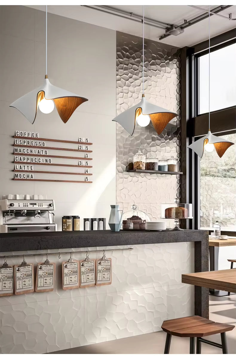 Suspensions blanches en résine effet bois au design organique et sculptural installées au-dessus d’un bar contemporain