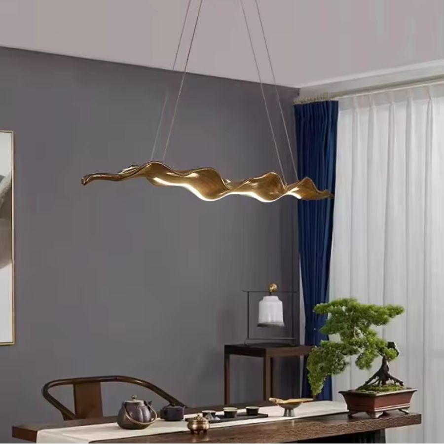 Suspension feuille ondulée marron au style sculptural et organique, au-dessus d’une table contemporaine