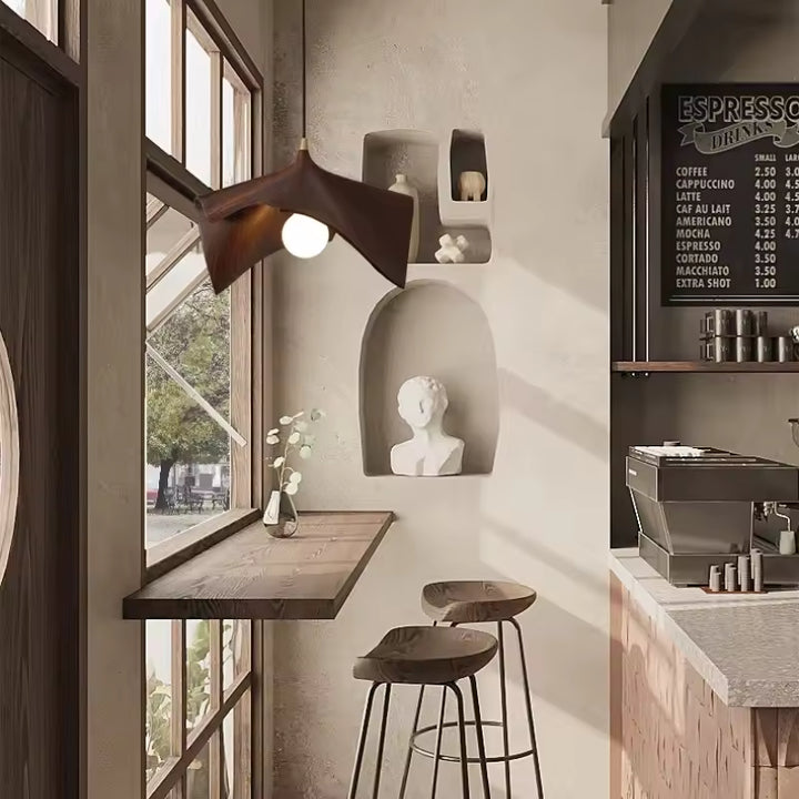 Suspension feuille en résine effet bois au design organique et moderne, installée dans un espace bar chaleureux