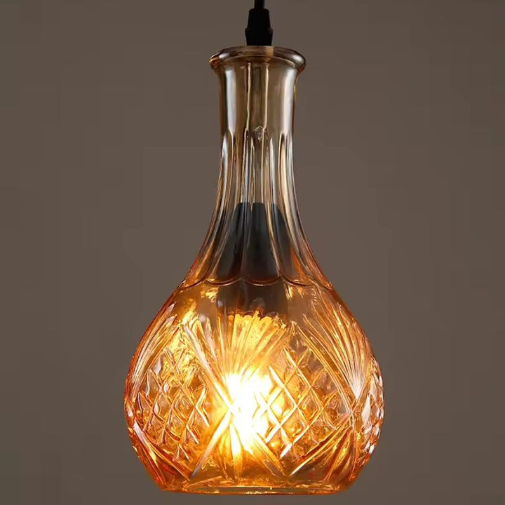 Suspension flacon en verre taillé ambré, aux motifs géométriques et à la lumière chaude dans un esprit vintage élégant