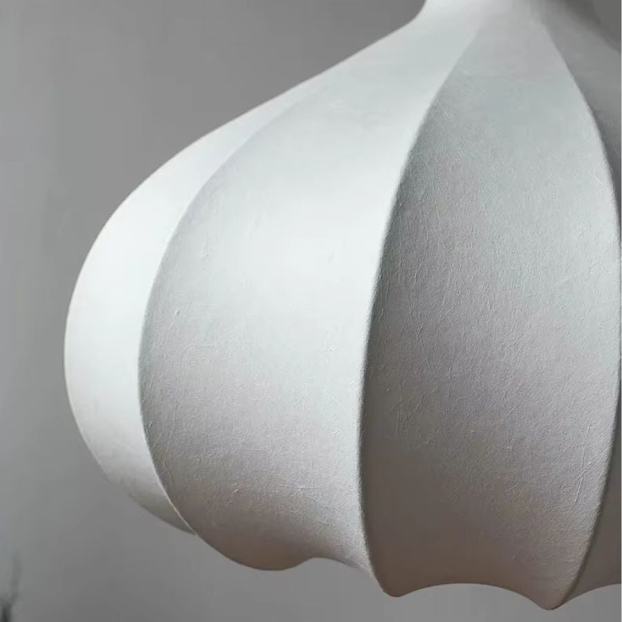 Gros plan sur les pétales bombés en soie blanche d'une suspension japonaise au design organique et minimaliste.