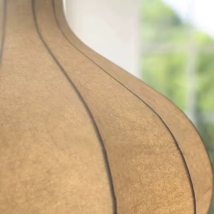 Gros plan sur la texture délicate de la soie et les nervures courbées d'une suspension florale au style Japandi naturel.