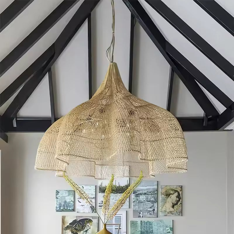 Sous une charpente apparente, cette suspension fleur en rotin tressé déploie une corolle bohème et organique