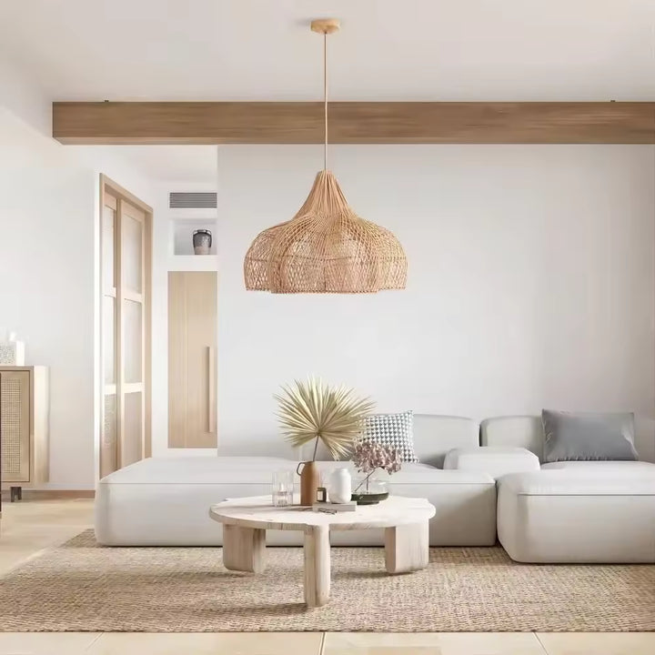 Une large corolle en rotin tressé forme une suspension fleur au style naturel, organique et sculptural