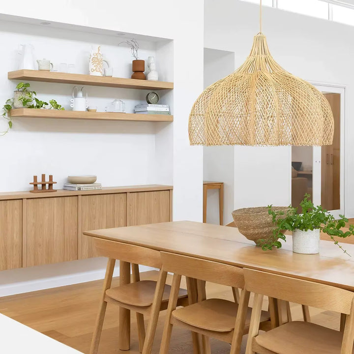 Au-dessus d’une table en bois clair, cette suspension fleur en rotin tressé souligne un style scandinave et naturel