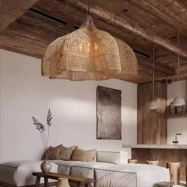 Sous un plafond en bois, cette suspension fleur en rotin tressé renforce une ambiance rustique, naturelle et organique