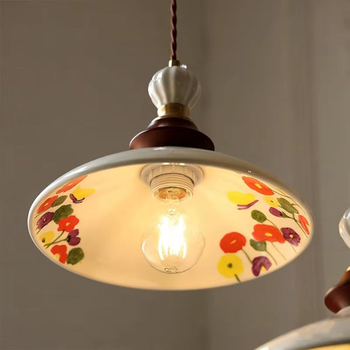 Abat-jour en céramique fleurie d’une suspension vintage romantique, illuminé par une ampoule à lumière chaude