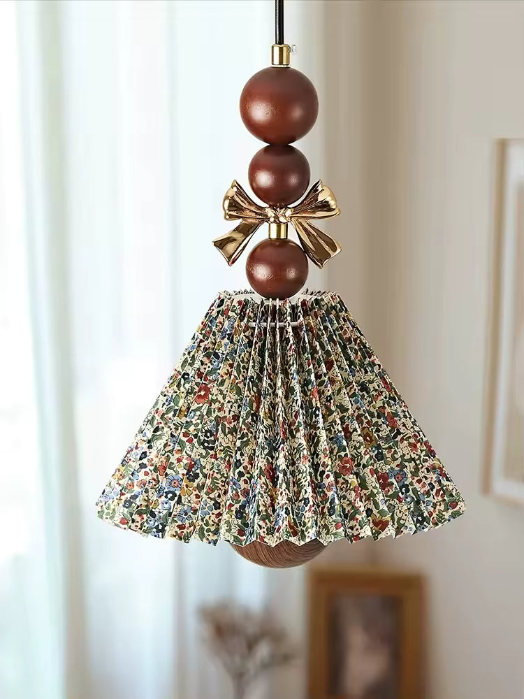 Suspension florale plissée en tissu imprimé et bois brun, ornée d’un nœud doré au charme vintage et romantique