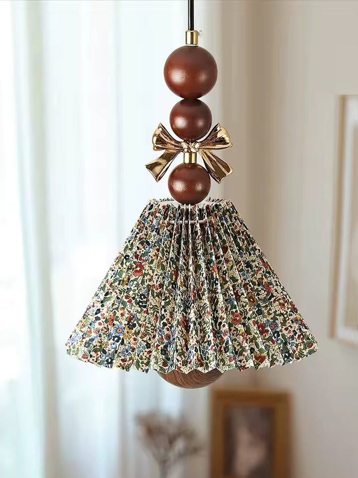 Suspension florale plissée en tissu imprimé et bois brun, ornée d’un nœud doré au charme vintage et romantique