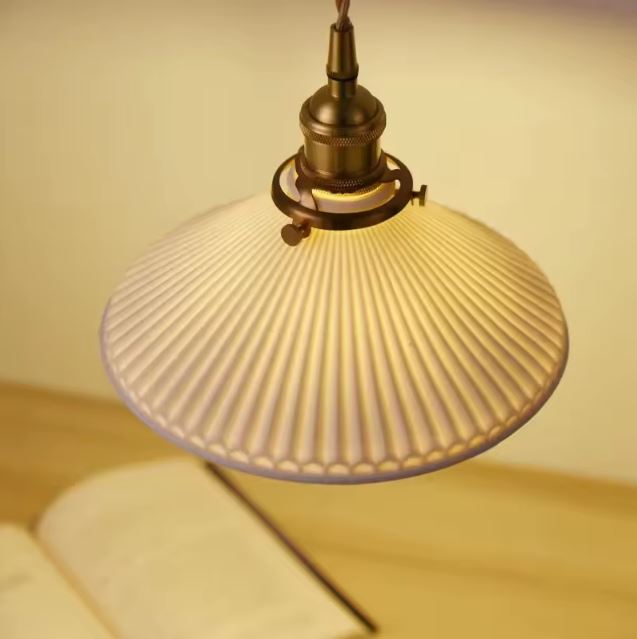 Suspension Flûte Blanche en céramique godronnée diffusant une lumière chaude, idéale pour un bureau au style rétro et raffiné.