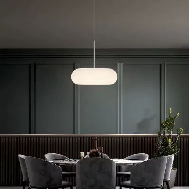 Suspension Galet Flottant en Verre Opalin au-dessus d'une table ronde dans une salle à manger au style contemporain raffiné