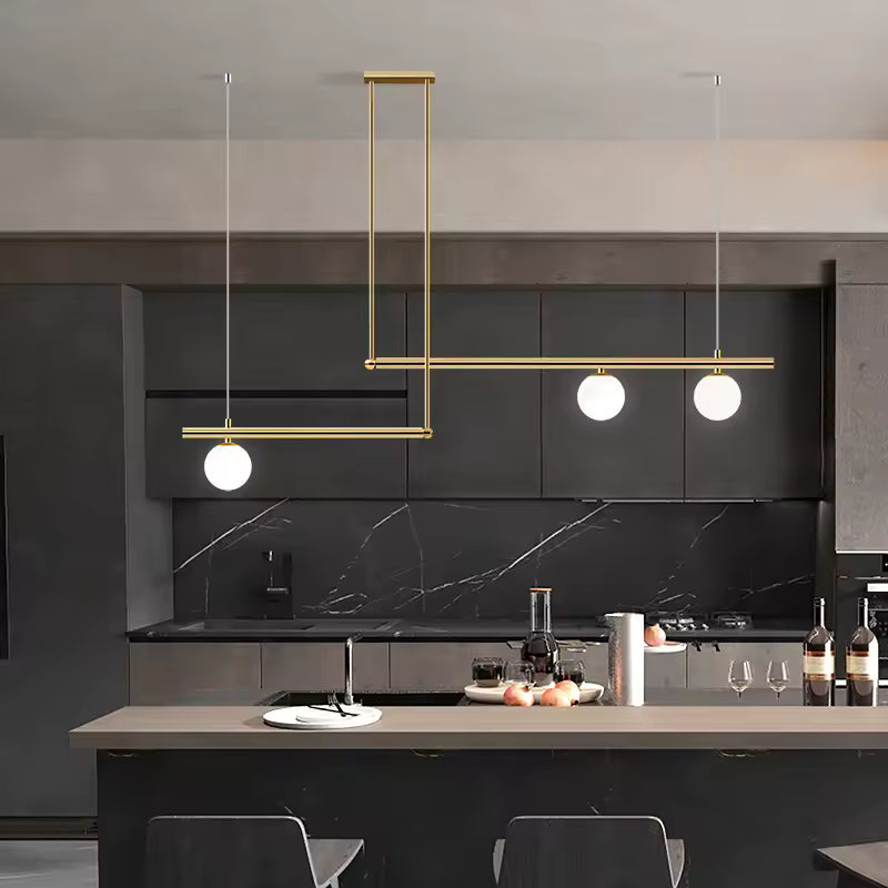 Suspension dorée à lignes décalées et 3 globes opalins, mise en scène dans une cuisine contemporaine