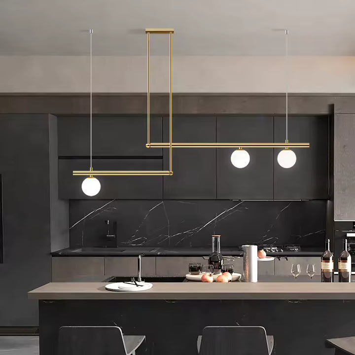 Suspension dorée à lignes décalées et 3 globes opalins, mise en scène dans une cuisine contemporaine