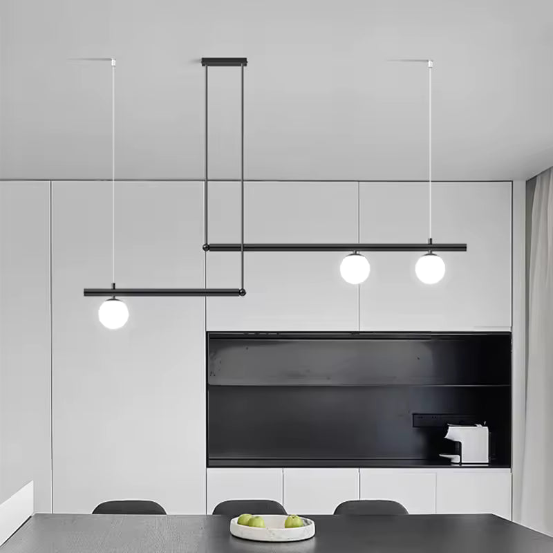 Suspension noire à lignes décalées et trois globes opalins, intégrée à une salle à manger moderne et minimaliste