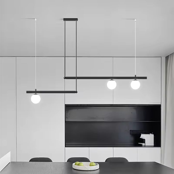Suspension noire à lignes décalées et trois globes opalins, intégrée à une salle à manger moderne et minimaliste