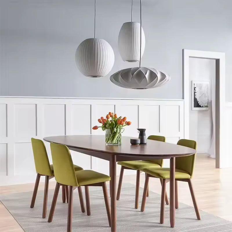 Suspension globe en soie blanche plissée au design organique et contemporain, mise en scène dans une salle à manger