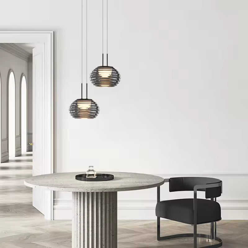 Duo de suspensions globe en verre fumé strié, au style élégant et contemporain au-dessus d’une table ronde