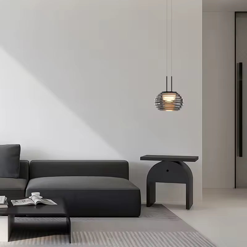 Suspension globe strié en verre fumé au design contemporain, mise en scène dans un salon moderne et épuré