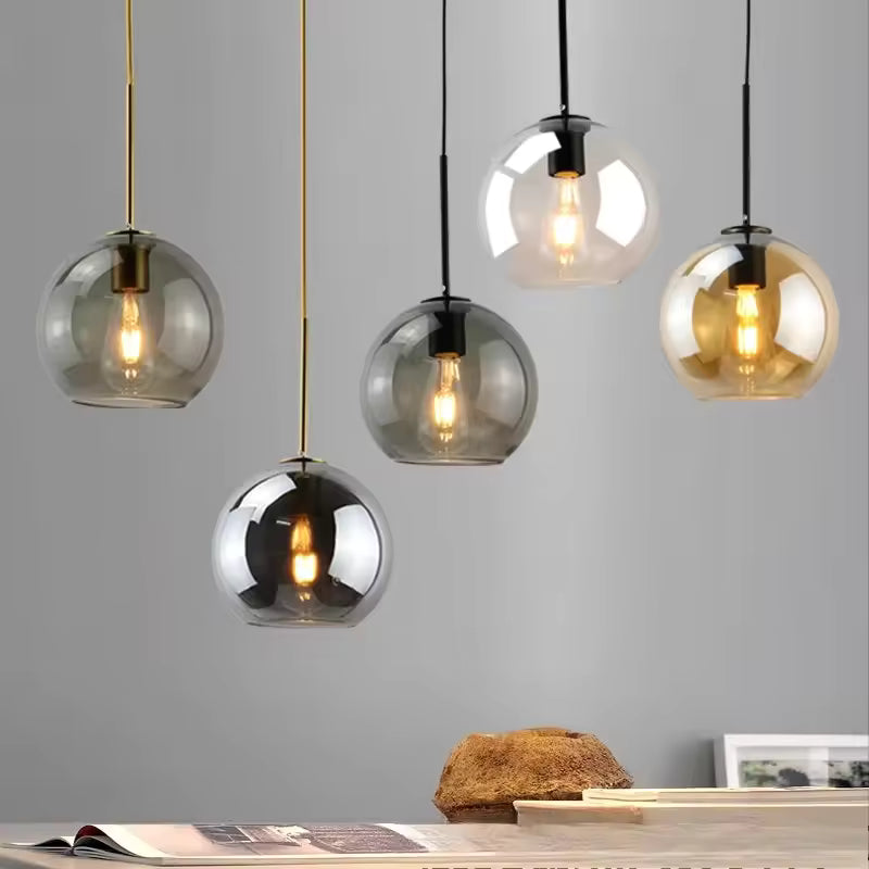 Suspensions globe en verre coloré à ampoule filament apparente, déclinées dans un design contemporain
