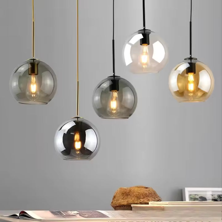Suspensions globe en verre coloré à ampoule filament apparente, déclinées dans un design contemporain