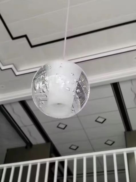 Suspension globe en verre bullé effet cristal, luminaire design contemporain pour intérieur élégant et lumineux.