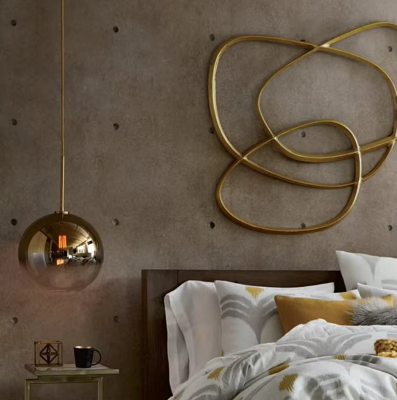 Près du lit, une suspension globe en verre fumé doré apporte une touche vintage et sophistiquée à la chambre