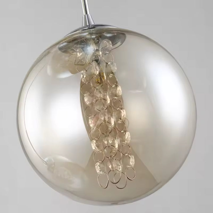 Gros plan sur un globe en verre cognac de la suspension, orné de perles facettées pour un effet lumineux raffiné
