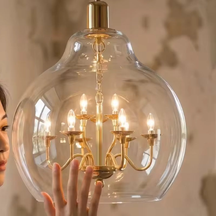 Gros plan sur un globe en verre transparent abritant un lustre doré lumineux au style chic et classique revisité