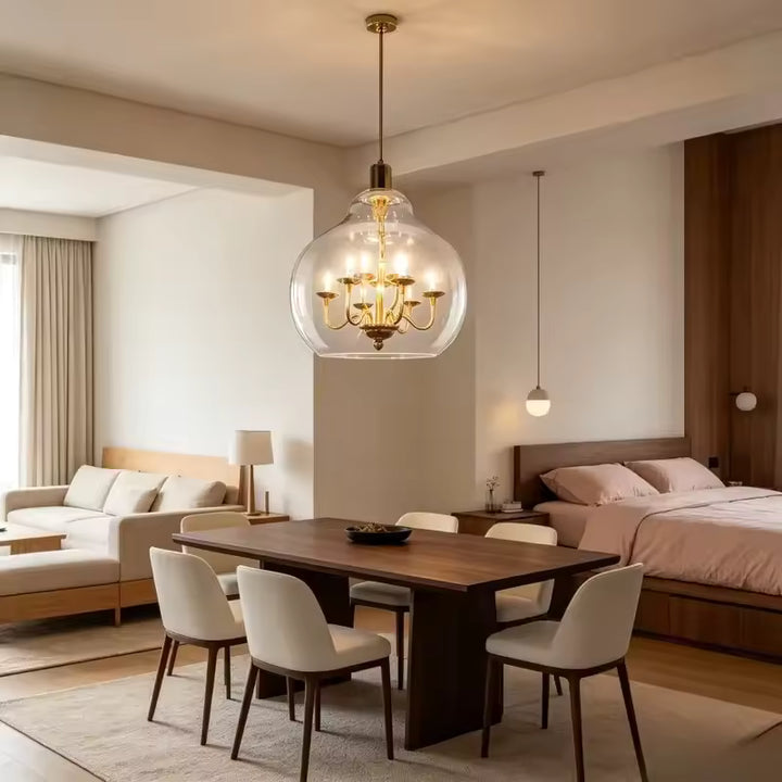Suspension globe en verre transparent avec lustre doré, mise en scène dans une salle à manger élégante et contemporaine