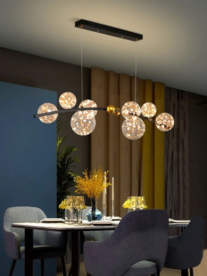 Suspension à globes en verre installée au dessus d'une table à manger au design moderne