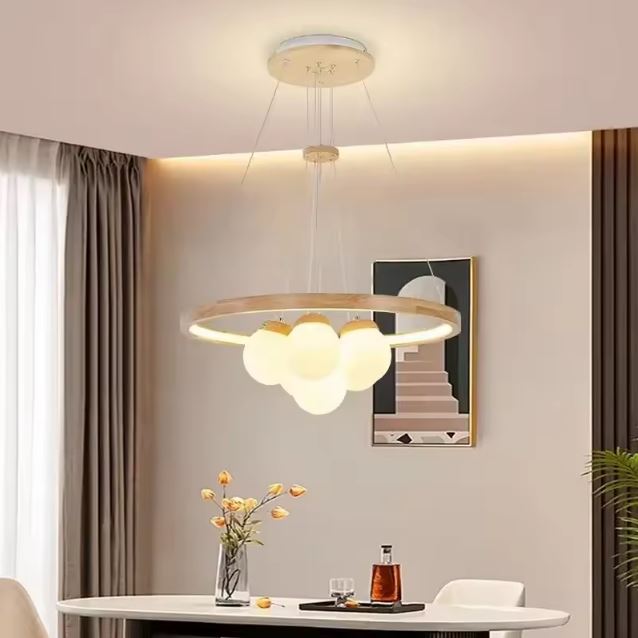 Suspension en bois naturel avec globes en verre dépoli et cercle lumineux, parfaite pour une salle à manger douce et moderne.