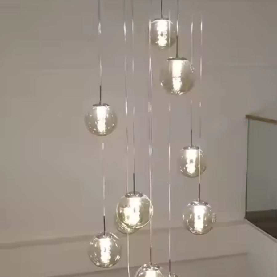 Suspension à globes en verre étagés comme une constellation lumineuse, au design aérien et contemporain