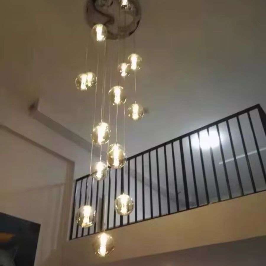 Suspension à globes en verre vue en hauteur, composition lumineuse élancée au style design pour espace à double hauteur